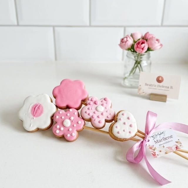 Buquê de biscoitos decorados em formato de flores e coração com laço rosa
