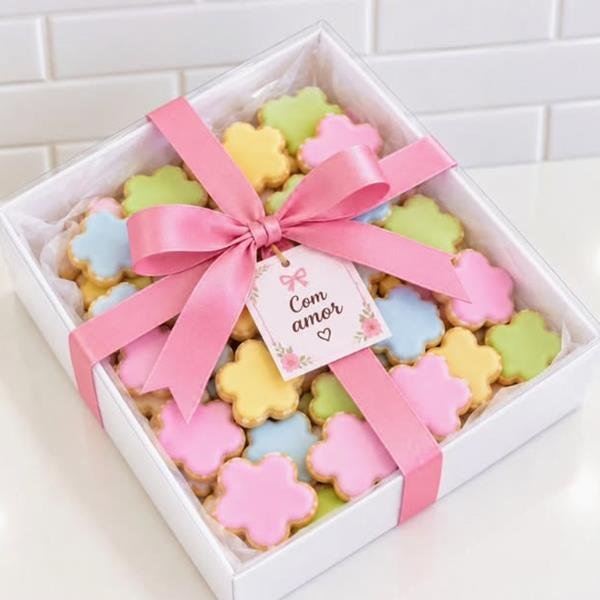 Caixa de presente com biscoitos coloridos em forma de flor e laço rosa